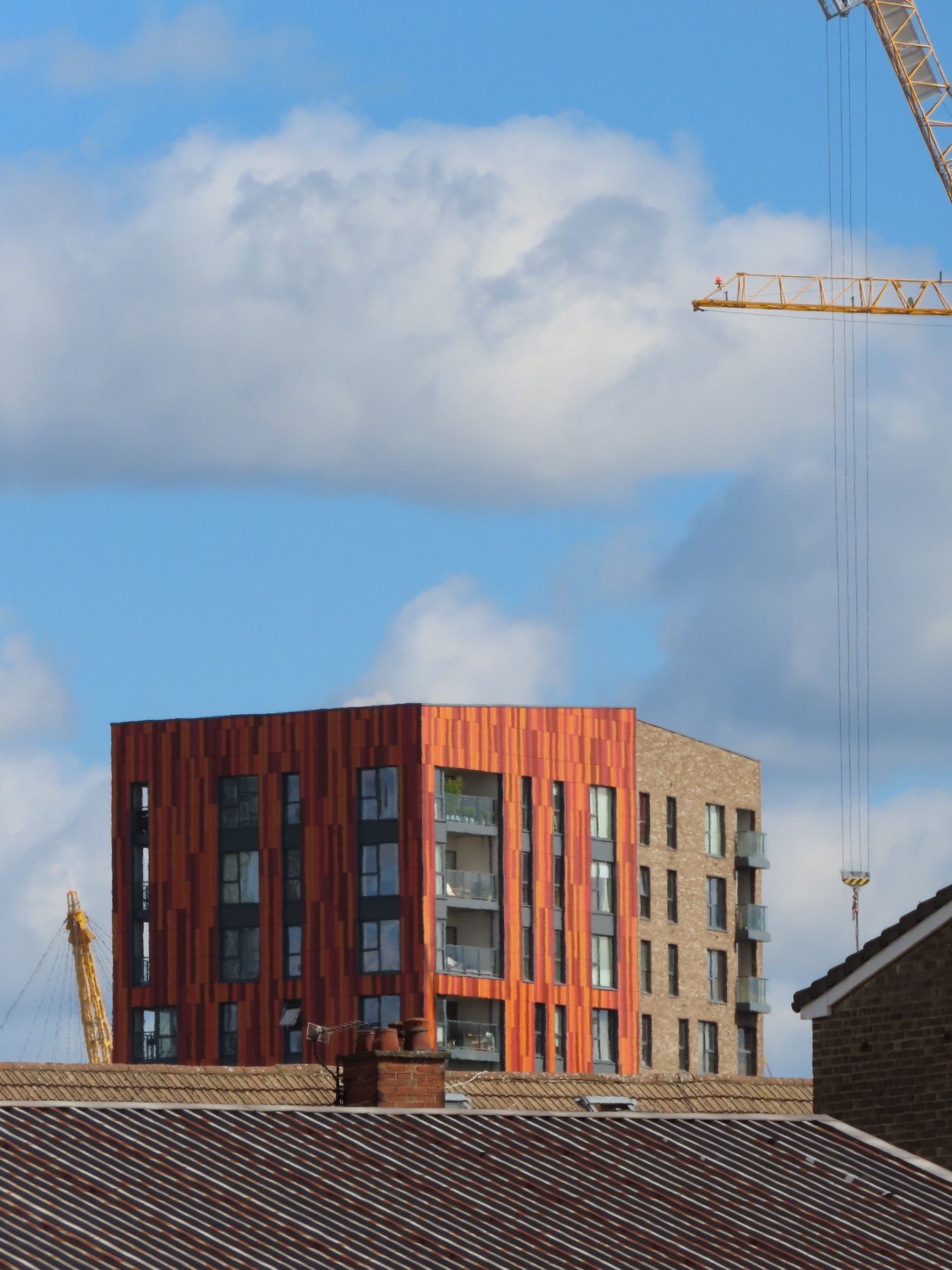 New brick apartment building with a crane at New Union Wharf, London