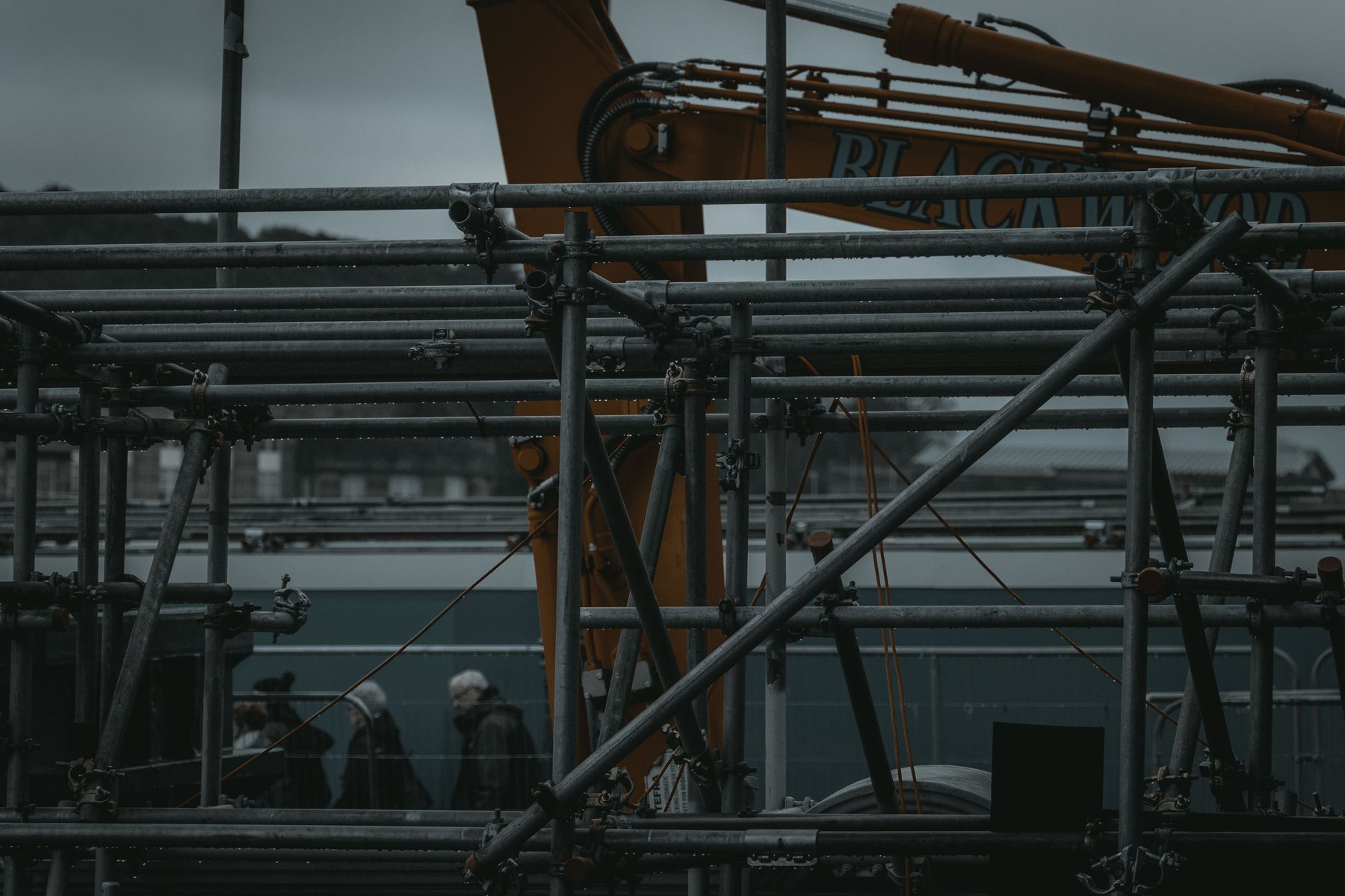 Scaffolding and machinery on a site in Edinburgh with workers in the background